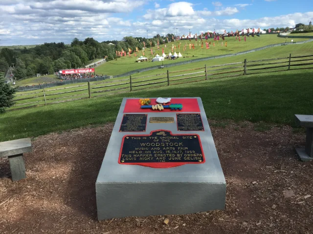 The stone monument marking the 1969 festival field at Bethel, with the sloping meadow behind