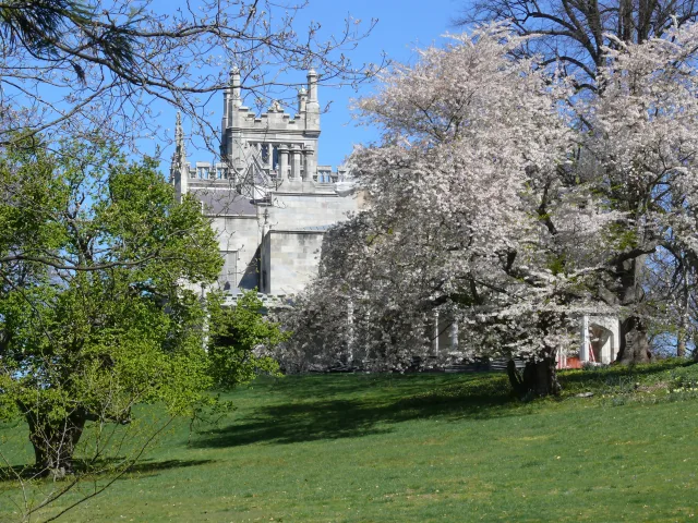 The Gothic Revival stone facade and turret of Lyndhurst, above its lawn in Tarrytown
